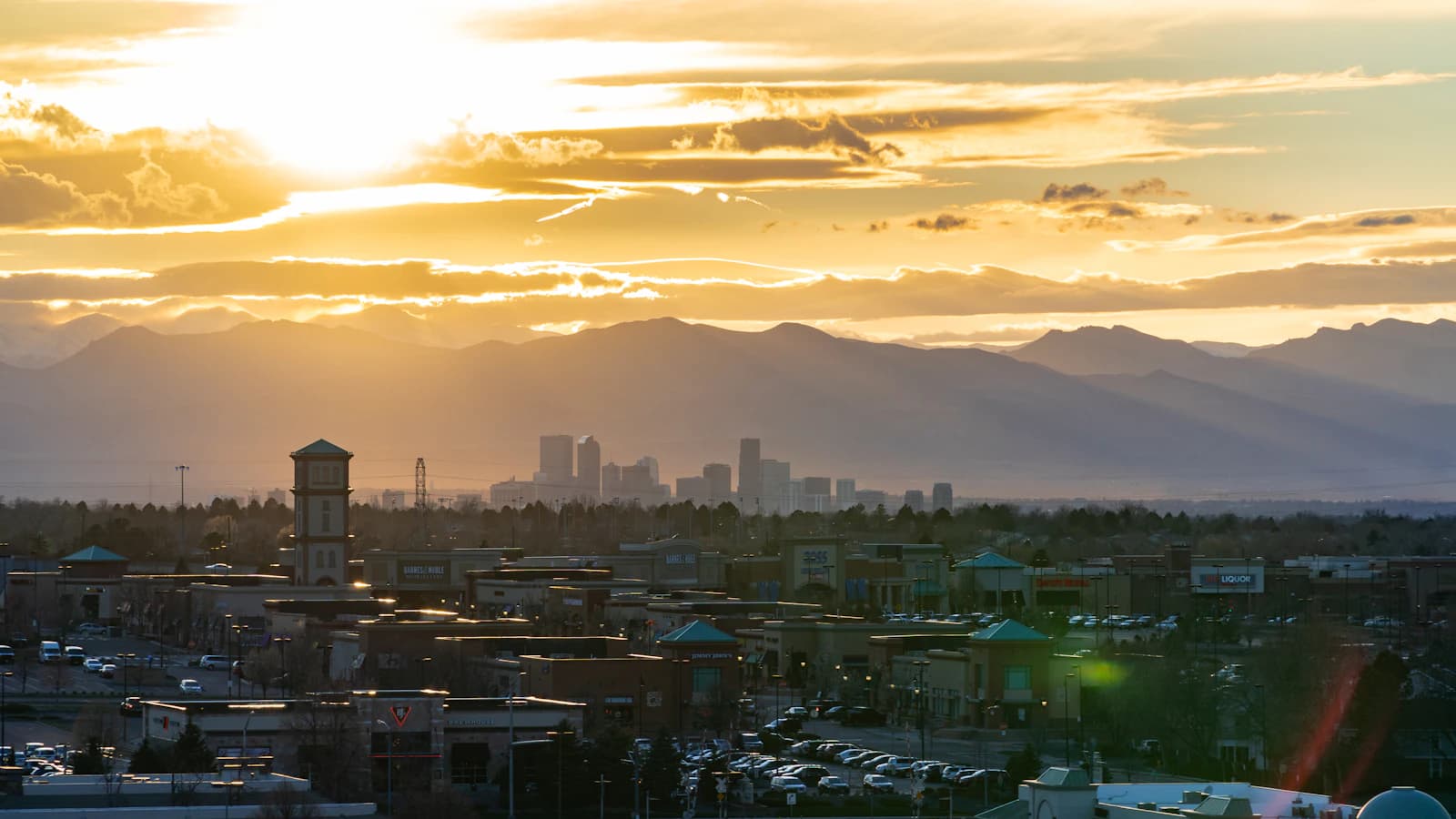 The Denver skyline beneath the Front Range at sunset